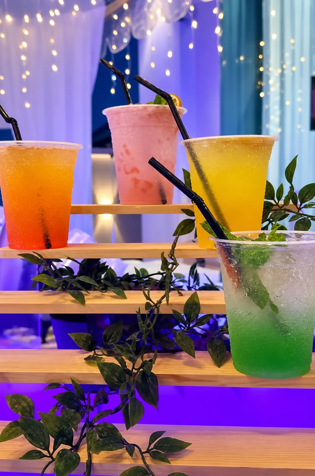 Colourful drinks presented on a decorated wooden display.