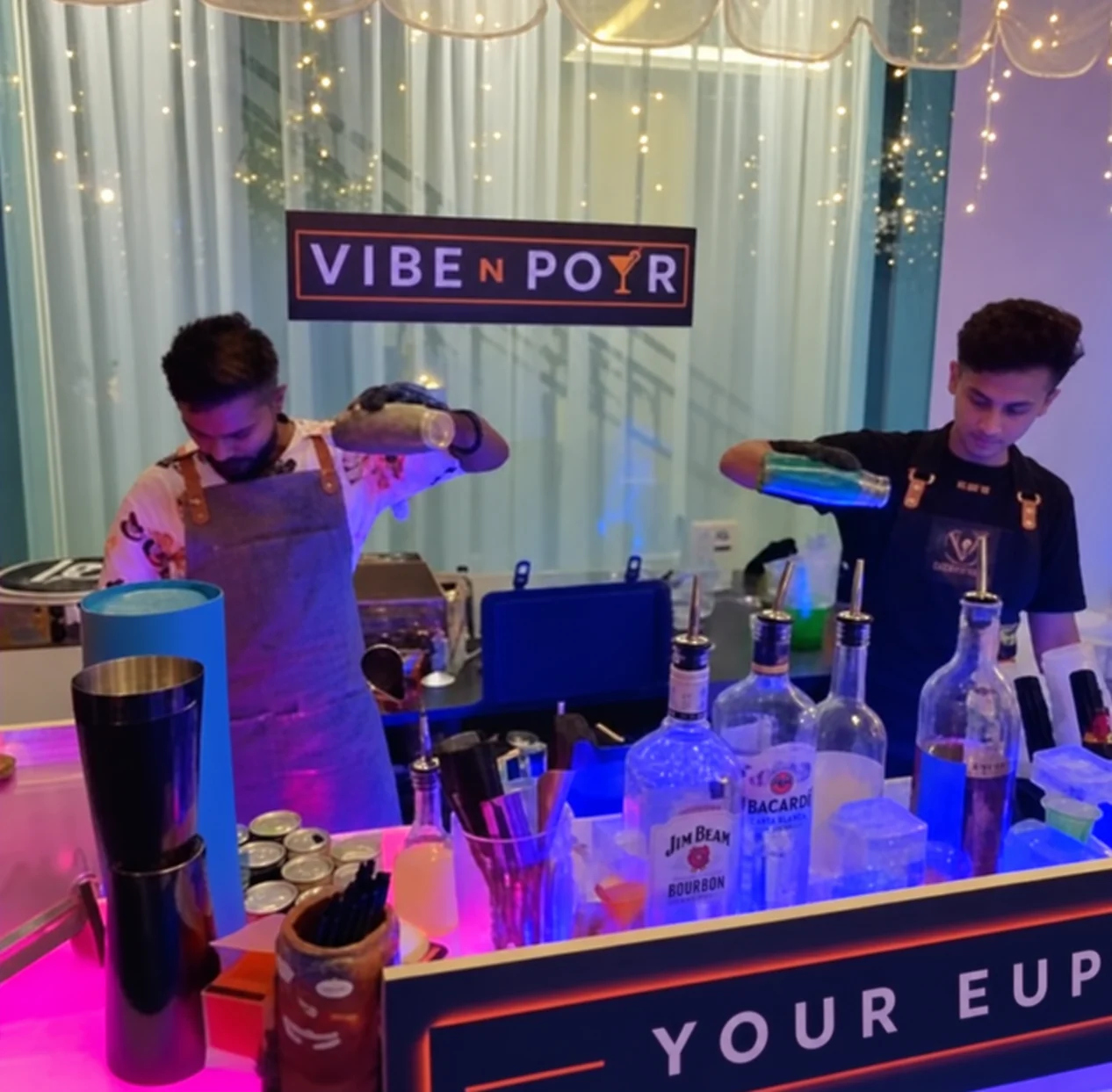 Vibe N Pour bartenders preparing drinks behind the mobile bar.