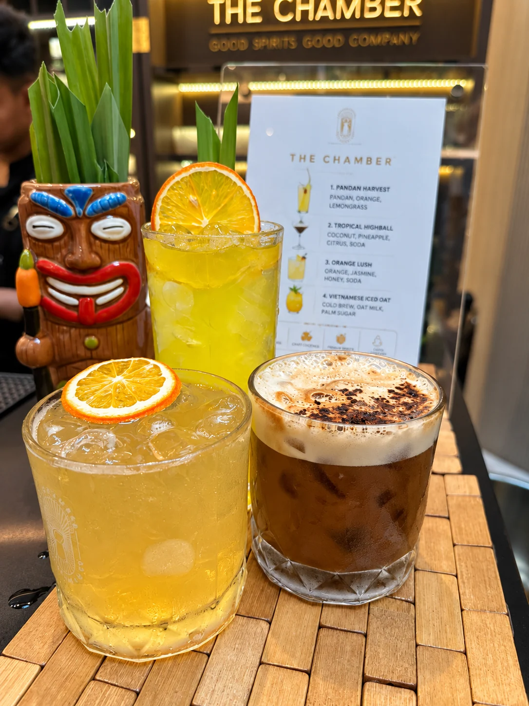 Three signature cocktails served with citrus garnishes.