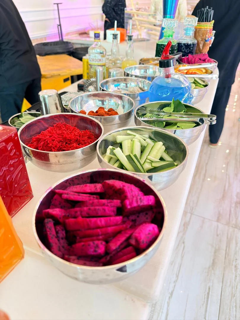 Dragon fruit, cucumber, citrus and fresh leaves arranged along the mobile bar.